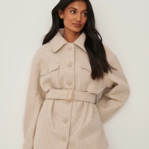 Beige kappa ifrån NA-KD  - Hej, säljer min kappa då det inte känns som min stil! Storlek 34 och sitter bra på mig som är en 36 och kan ha hoodie eller tjockare tröja under utan problem! Knappt använt så den är i nyskick! Kom jättegärna med pris förslag och fler bilder privat!💗