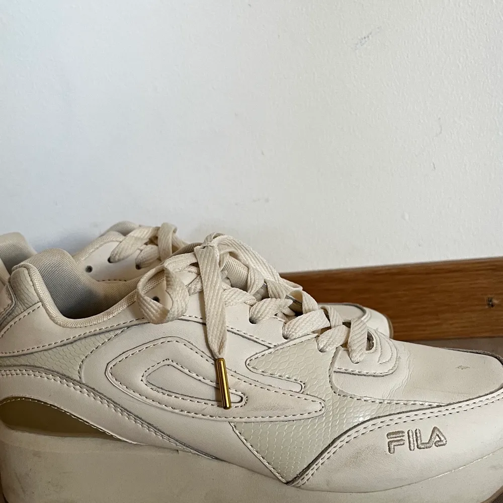 Vita fila sneakers i storlek 39. Har använts ett fåtal gånger, men säljs då jag inte använder de. Köparen står för frakt.. Skor.