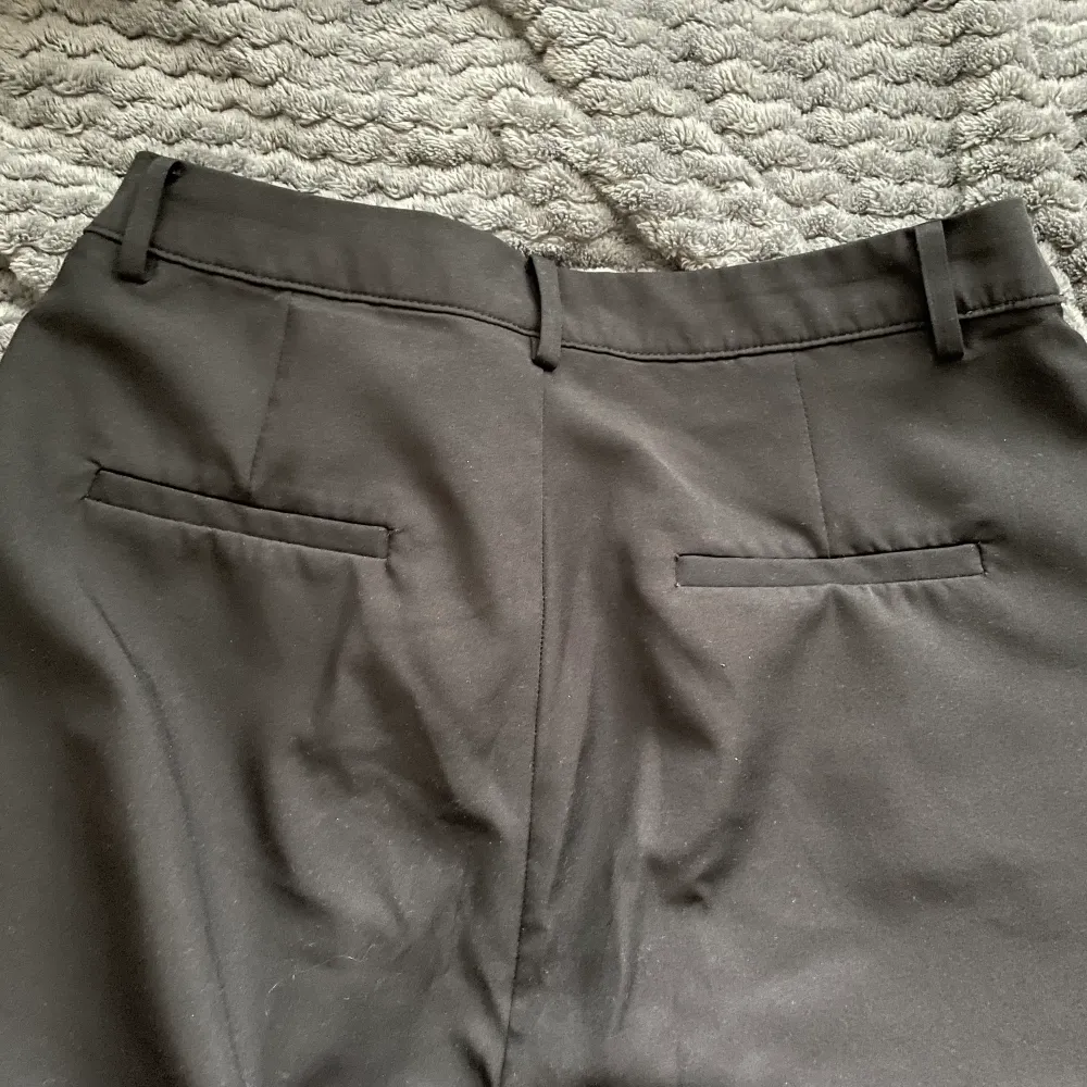 Ett par fina utsvängda kostymbyxor utan skador med fram fickor knapp och dragkedja. Jeans & Byxor.