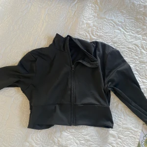 Träningskläder  - Träningsbyxor med scrunch, ombyte. Stl S. Aldrig använda. Croppad tränings ziptröja. Stl S. Aldrig använd. Köpes tillsammans.