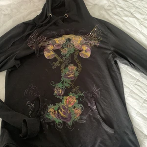 Svart tunn hoddie med en fin design - Jätte fin tunn hoddie med luva!! Glittrena e borta men det ändå fint ut. Vill sälja den för 50-80kr vilket är ganska billigt. Kontakta om due intresserad så kan vi komma till ett rimligt pris!!