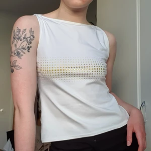 vitt linne strl M - Vitt linne i baddräktsliknande material som har guldprickar på framsidan! Står storlek M/L men funkar också till S beroende på hur man vill att det ska sitta. Inte genomskinligt! Kan nog användas som tankini om man är modig