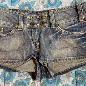 Low-waisted short shorts - 2000s vibe low waisted short shorts med små gula detaljer och små blå broderade fåglar jättelitet på baksidan. Det står att de är size 8 men skulle säga att de är mer som storlek 4. Midjemåttet är 77cm (fast de är som sagt low-waisted så det är mer som höft mått). Jag köpte shortsen second hand på sellpy men de var för små :((