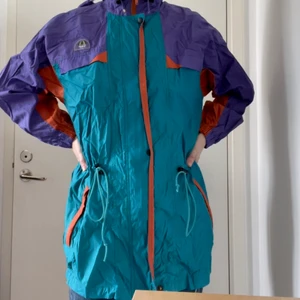 Retro Vindjacka täckjacka medium large  - Retro jacka från Campagnolo i superfint skick. Uppskattar till storlek medium/large dam. Jag (på bilderna) är en normal medium dam. Ofodrad. Liten skada på dragkedja (se bild), men fungerar ändå. Två bröstfickor och två fickor med dragkedja. 