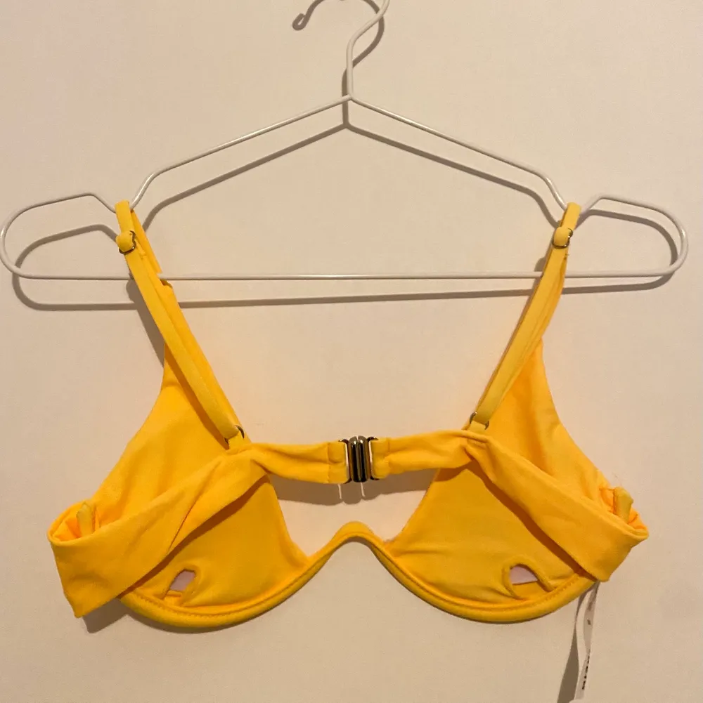 En gul bikini i storlek S. Den är gulare än vad den ser ut att vara på bilden. Bra kvalitet. Justerbara axelband. Knäpper i ryggen och har även inlägg.. Övrigt.