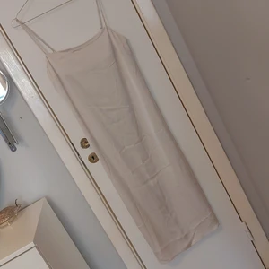 Slipklänning med slits på båda sidor - Ca vadlång rak slipklänning med reglerbara band. Slits på båda sidor. Gammal men oanvänd med lapp kvar. Sitter tyvärr skitfult på mig så kommer inte visa hur den sitter 🥲