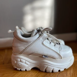 VitaBuffalo London, Noumera strl 37 - Buffaloes London, Noumera, vita Storlek 37, men stora i storleken och passar en 38. Använda men inte slitna. Lite fläckar på sulan som man ser på bild 3, går säkert att få bort med något medel. Säljer pga kommer tyvärr ej till användning. Nypris: ca 1500 kr Priset går att sänka vid snabb affär.