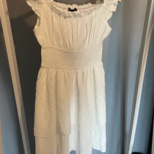 Söt klänning - söt klänning från shein, vit med rutch tyg och volanger med prickar! aldrig använd, köpt inför sommaren men passar inte min stil, är en xs men den är väldigt stretchig så skulle säga xs-s