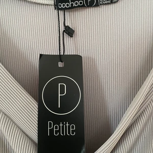 Grå klänning  - Högst bud vinner  Ny med prislappen kvar Klänningen är ljus grå stretchig i tyget. Stl 36/38 (s/m)