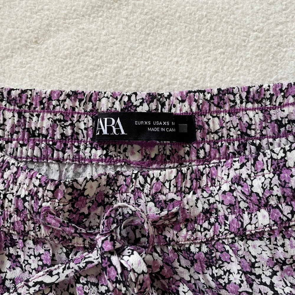 Småblommig lila kjol från zara i storlek Xs, helt oanvänd 💜✨ Resår i midjan och går även att dra åt, finns shorts under,  Nypris = 279kr. Kjolar.