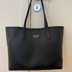 Guess väska  - Nästan oanvänd svart Guess väska, därav som nyskick. Leopardmönstrat innertyg. Väldigt rymlig.  Nypris: 1 499kr. Säljes för 400kr + 66kr spårbar frakt :) 