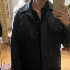 Skinnjacka Roco Baroco vintage med knappar - Vintage skinnjacka från Roco Baroco, vintage. Med fickor och knappar. Boxig modell, oversize med lite vadderade axlar.