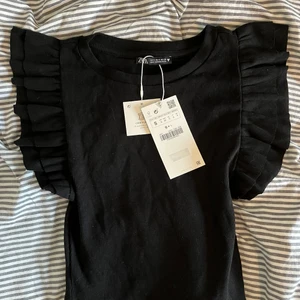 Volangtopp från zara - En svart volangtopp från zara. Aldrig använd och med prislapp kvar. Köpare står för frakt✨