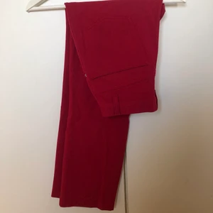 Kostymbyxor - Röda kostymbyxor i stretchigt material. Ganska korta, till fotknölarna på mig som är 163. Rymliga fickor både fram och bak. j