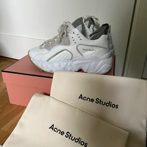 Acne Studios Manhattan Nappa storlek 35 (passar 36) - Beiga/vita acnesneakers i storlek 35, stora i storleken så passar 36. Originalbox samt oanvända dustbags medföljer. Fint skick utan anmärkningar. Möts upp i Gbg, annars står köparen för frakten på 116kr spårbart försäkrat med postnord! Köpta för 4300kr. 
