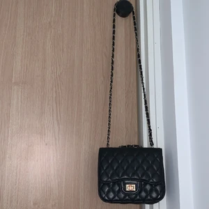 Axelremsväska  - Svart och guld axelremsväska.  