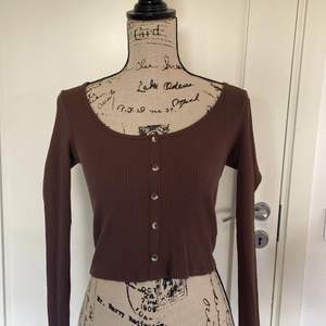 Brun långärmad tröja i ribbat material med fejk-knappar från Gina Tricot. Storlek S. Möts upp i Jönköping, annars står köparen för frakten 💗