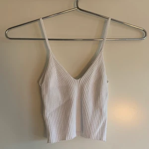 Vitt linne, Bershka - Ett kort, superfint, tunt linne från Bershka! Det är inte genomskinligt och sitter som handen i handsken. Det är väldigt stretchigt vilket gör att det passar dig som är S/M också, pass på! Först till kvarn!