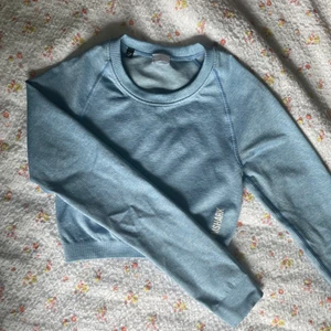 Topp från gymshark - Blå långärmad tröja från gymshark som är slutsåld på hemsidan. Köpte för 399 men säljer för 200. Har nästan aldrig använt den så den är i riktigt bra skick!
