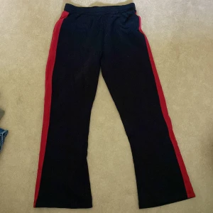 Mjukisbyxor - Svarta mjukisbyxor med röd rand på sidan, strl 170.                   150kr