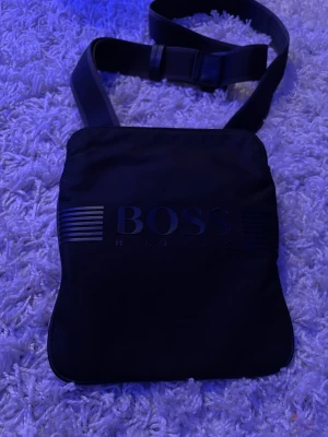 Hugo boss väska  - Säljer denna Hugo boss väska. Vissa bokstäver på märket är i sämre skick , och även en bondbönor saknas (dock inget man tänker på). Köpte denna väska för 1100kr . Lägg bud