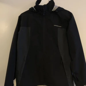 Regnjacka - Regnjacka från sports crosswear i svart/grått. Använd några fåtal gånger så den är i nyskick:) Frakten ingår i priset 🤩
