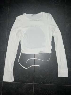 Vit topp med öppen rygg  - Säljer en vit topp med öppen rygg från NA-KD i storlek xs, pris 150kr