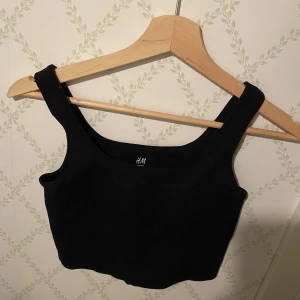 Sport topp H&M - Svart sport topp från H&M i ribbat material. Använt flitigt men inga defekter. Skriv vid frågor m.m!