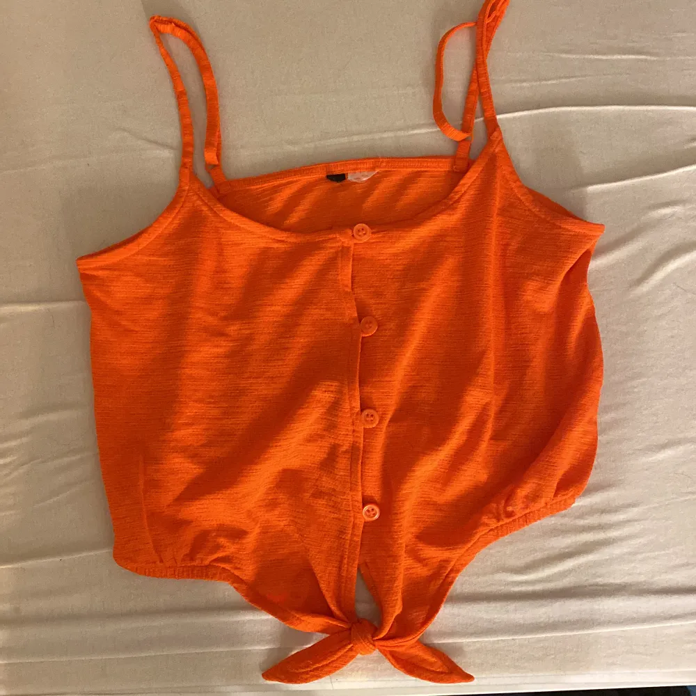 En super gullig liten topp i en Såå fin orange färg! Passar perfekt till sommaren när man fått lite färg på sig:) det är knappar som går att knäppa upp och man kan även knyta längst ner som man själv vill.  Storlek XS från H&M. Toppar.