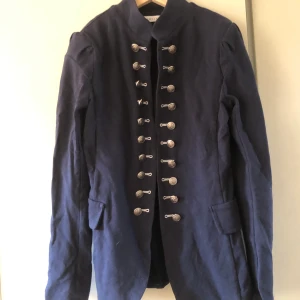 Kavaj - En marinblå ”dam kavaj” i storlek S. Den kom tyvärr aldrig till användning.