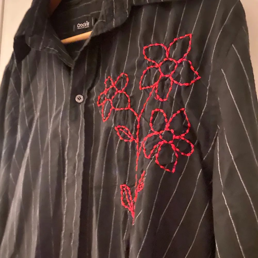 Svartvit randig skjorta med rött blommotiv. Mycket gott skick då jag knappt använt den. Från märket ”Crocker”. Storlek: large.❤️❤️. Skjortor.