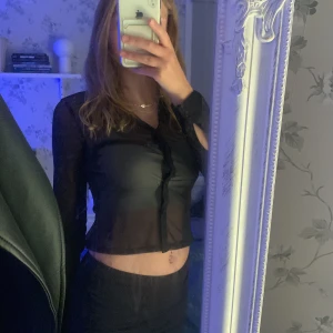 Genomskinlig tröja  - En genomskinlig tröja svart, knapp å krage. Endast testat. 