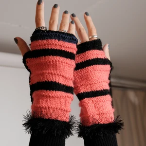 Stickade röda handledsvärmare  - One-of-a-kind stickade handledsvärmare I rött och svart. Stickad av Röda Korsets-stickgrupp i Västerort tillsammans med Ebba Martin. Alla pengar från budgivningen går oavkortat till Röda Korsets arbete för att hjälpa människor i kris och katastrofer.