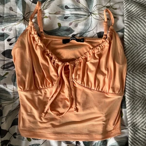 Topp - En orange topp i M från Bikbok