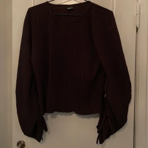 Brun blus - Brun räfflad blus med stora armar. Färg är svår att visa, lite mindre röd i verkligheten. 