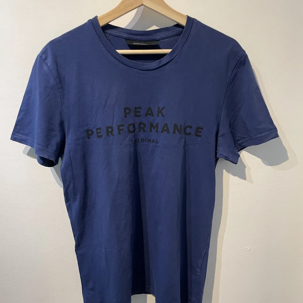En fin blå t-shirt från Peak Performance,stilren och bekväm i mycket bra skick!. T-shirts.