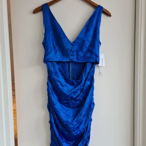 Ny klänning - Helt ny satinklänning! Aldrig använd. Västtopp, cut-out, ruched kjol