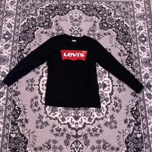 En svart Levis tröja som är tight