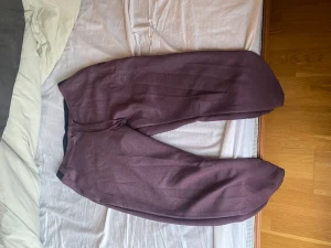 Under Armour mjukisbyxor - Under Armour mjukis byxor i lila färg i storlek L. Aldrig använda och bra kvalite samt skick. Även väldigt mjuka och bekväma. 500kr