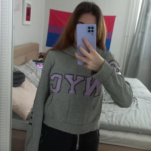 Huvtröja  - En grå tröja med NYC text. Använd men inte ofta. 