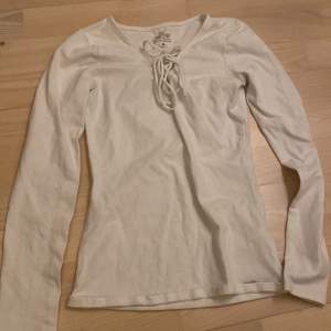 En långärmad vit tröja från hollister med en fin detalj. Knappt använd.
