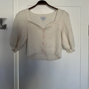 Knitted top - White top with Pink flower buttons.  Barely used. 