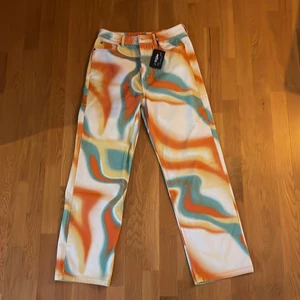 Jaded London byxor - Jaded London byxor ”Orange Abstract Wave Skate Jeans”. Helt oanvända med prislapp fortfarande på. Passform: Relaxed Fit. Storlek: 30. Originalpris: 779kr