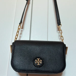 Tory Burch väska - Säljer min svarta jätte snygga Tory Burch väska med guld detaljer. Använd 2-3 ggr så är i nyskick.  Självklart äkta men har dock inget kvitto.