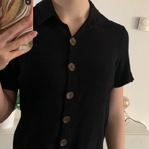 BikBok topp storlek xs - En fin topp/ T-shirt från BikBok i storlek XS men den passar S också. Den har en ficka vid bröstet och knapparna kan man öppna. 