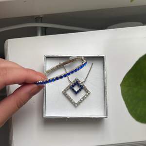 Smyckes set med blå och silverfärgade detaljer. Köparen står för frakt