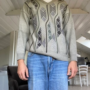 Grå sweatshirt - Grå stickad tröja med mönster i blått. Fin och knappt använd men lite kort i armarna för någon som bär XL. Skulle passa L alternativt mindre för en oversize fit.