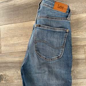 Högmidjade och trendiga jeans från Lee i väldigt gott skick. De är både otroligt bekväma och håller sig på plats.  Storlek: W26 L31 (passar S-M) 