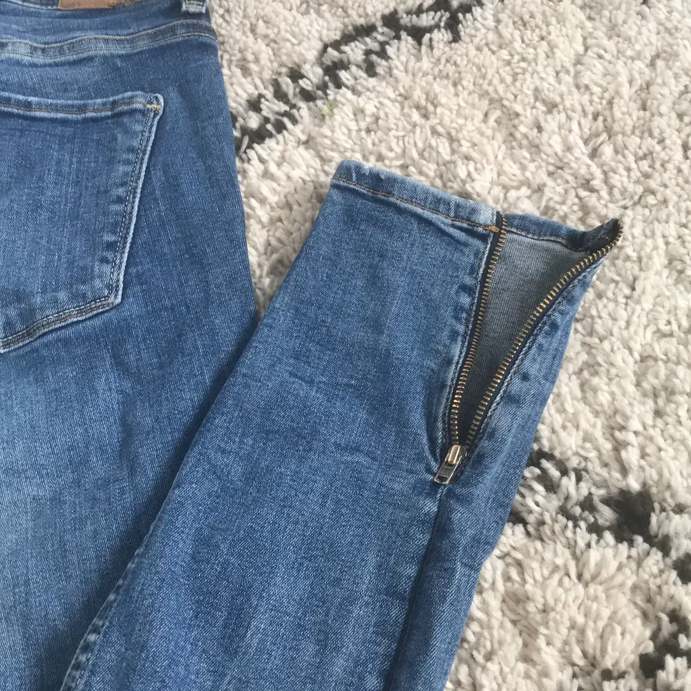 Här är ett par jätte fina lågmidjade jeans från Gina Tricot. Jeansen har dragkedjor längst ner på sidan av benet. Jeansen är änvända ett par gånger. Fråga bara om fler bilder. Buda gärna💓 . Jeans & Byxor.