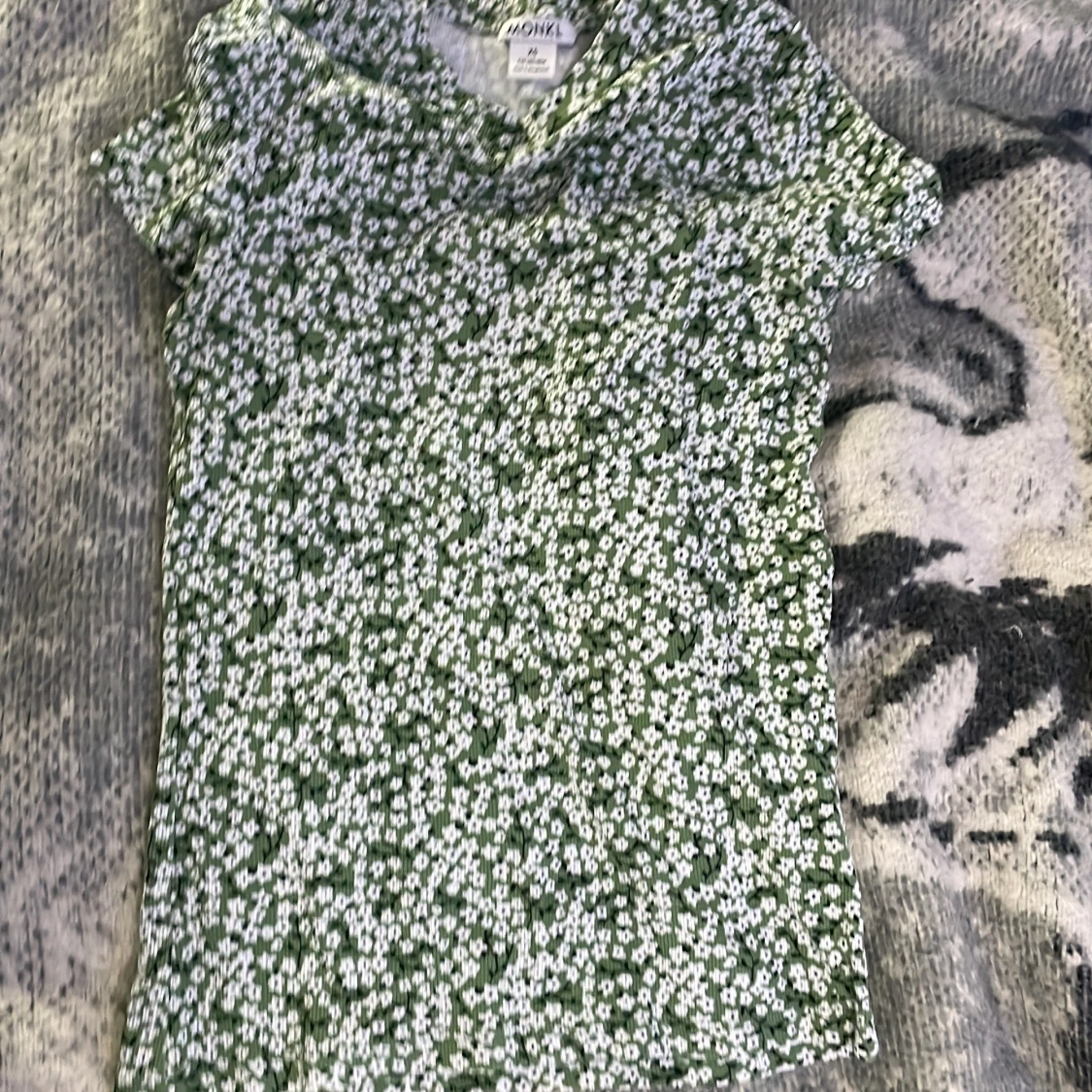 En grön tröja med vita blommor på - 90